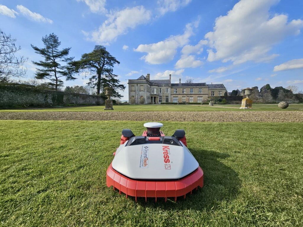 Professional robotic mower trimming formal lawns on a large private estate